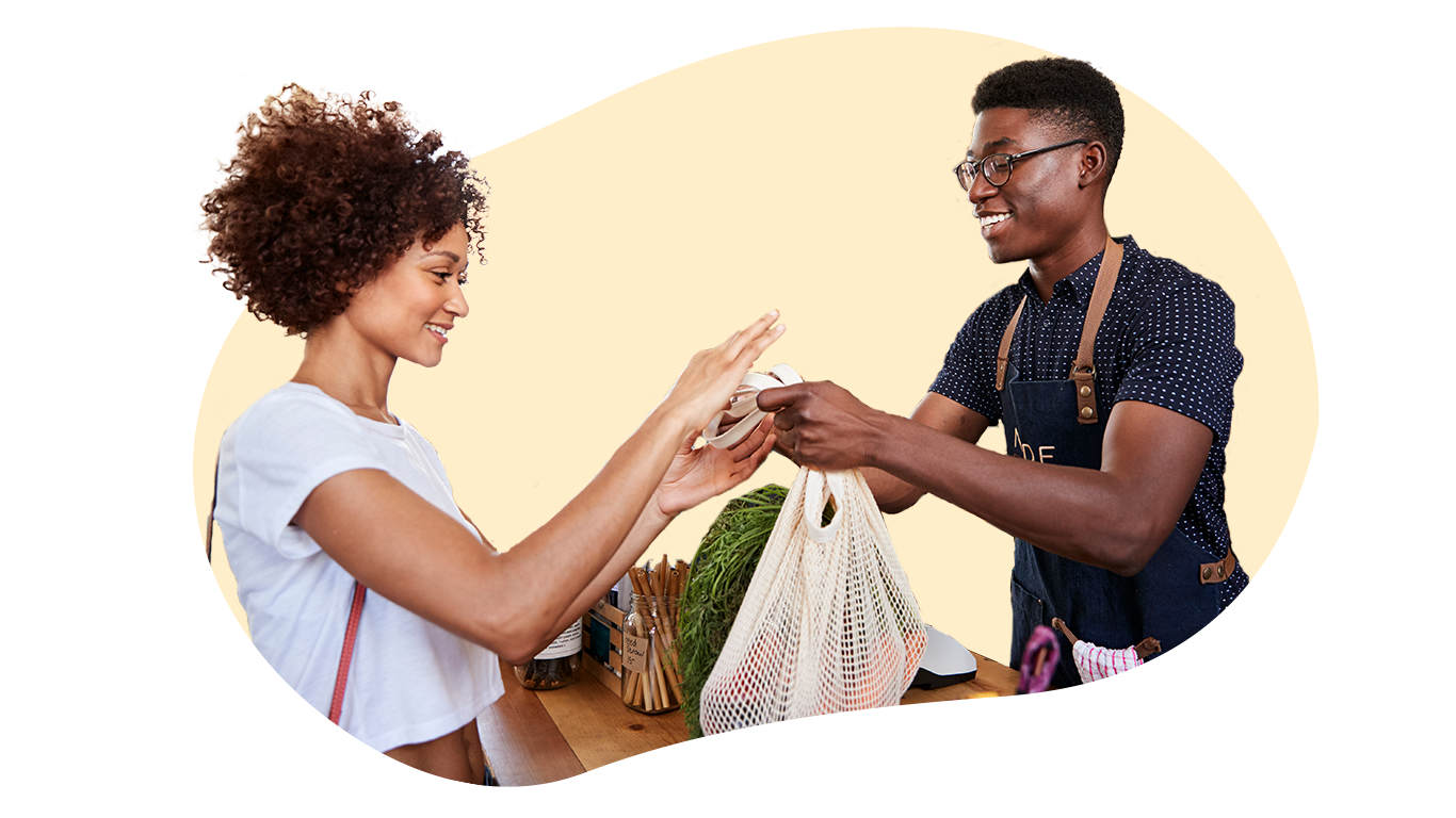 Man handing grocery bag to woman