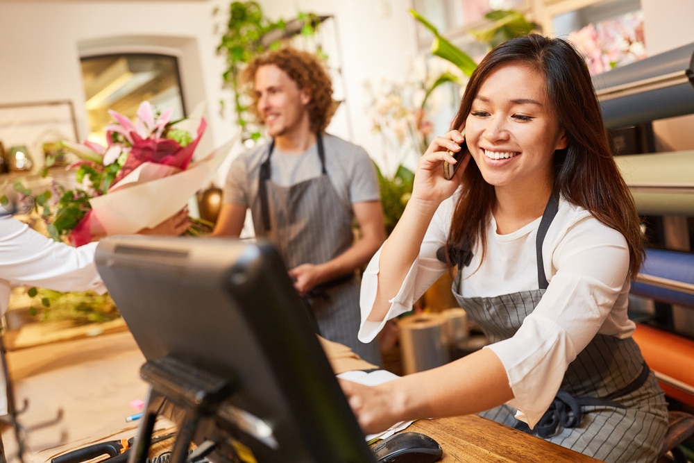 Woman merchant smiling in front of POS screen