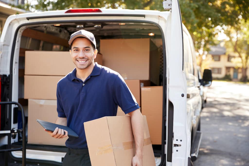 Delivery man in front of van full of packages