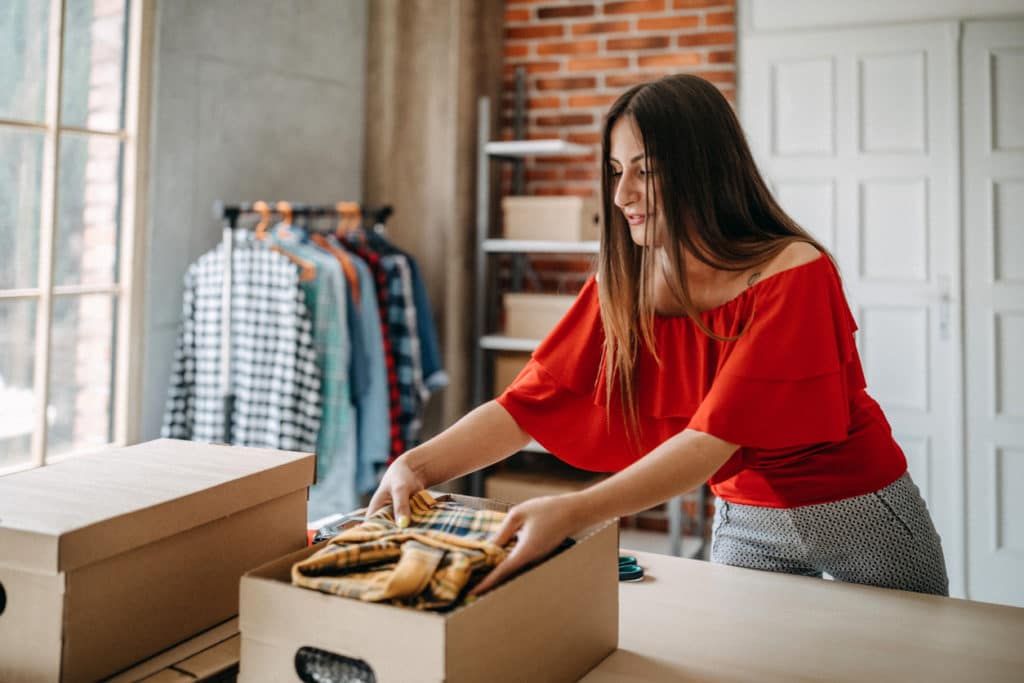 Woman merchant packing clothes for local delivery