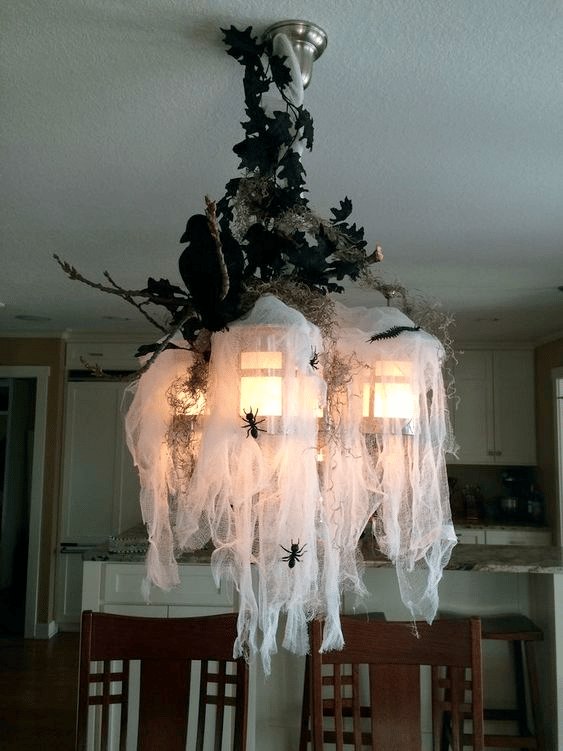 Faux spider webs used to decorate a chandelier