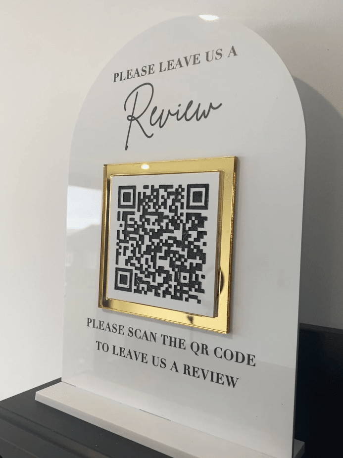 'Please leave us a review' sign with a QR code that links to the review site